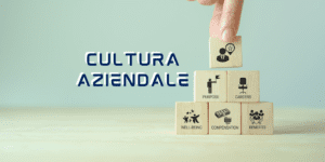 la scritta Cultura aziendale mostra una mano con dei cubi in legno con scritto sopra vari punti cruciali come wellbeing, purpose compensation